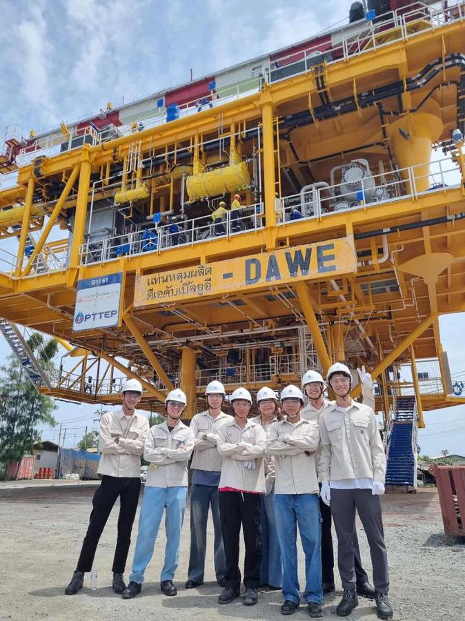 The PTTEP intern cohort in front of the DAWE wellhead platform